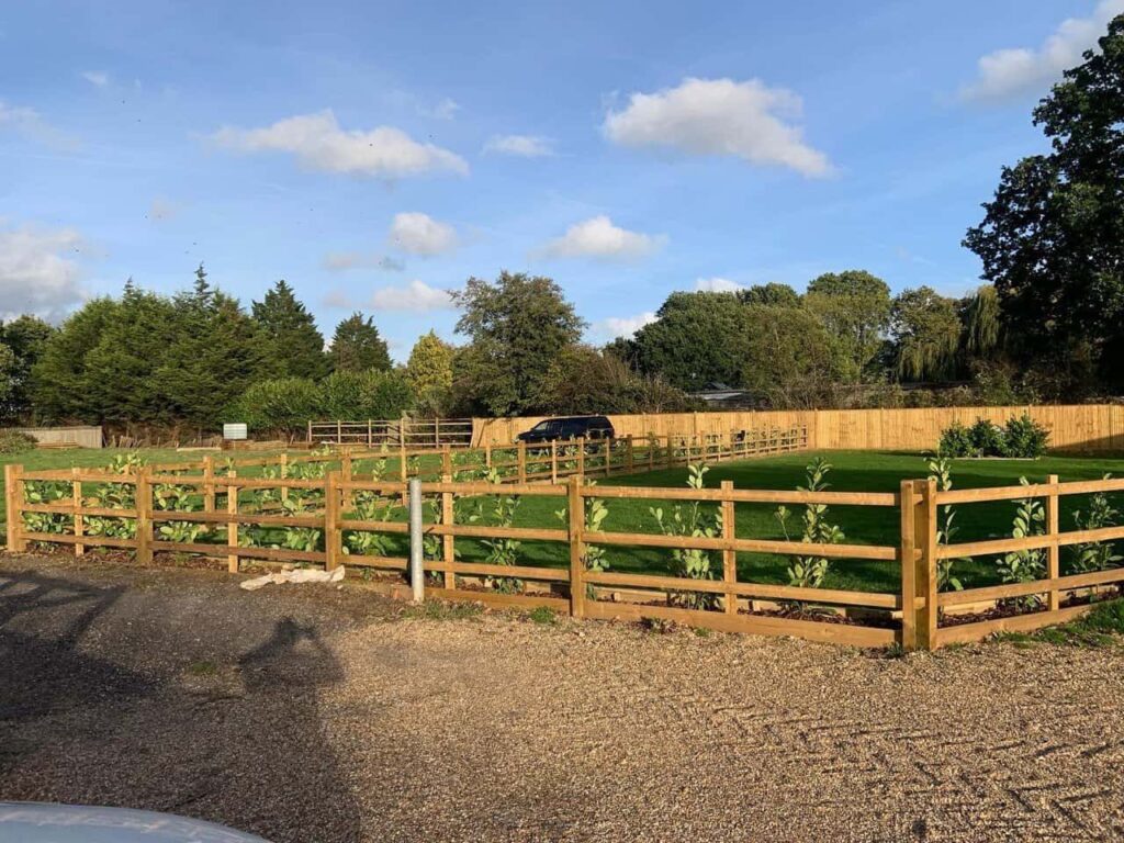 This is a photo of post and rail fencing with a gravel board installed at the base to create a flower bed, and at the rear is feather edge fencing along the edge of the garden. All works carried out by Fast Fix Fencing Wisbech